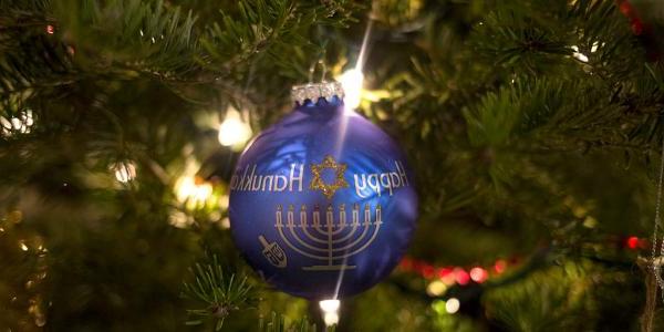 An ornament on a Christmas tree reads, "Happy Hanukkah."